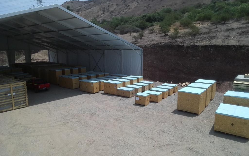 Galpón de bodegaje de Logística Inversol con carga de proyecto embalada en cajones de madera, ordenada bajo techo