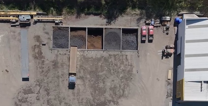 Vista aérea de los depósitos de material del patio de Logística Inversol, con un camión posicionado para cargar